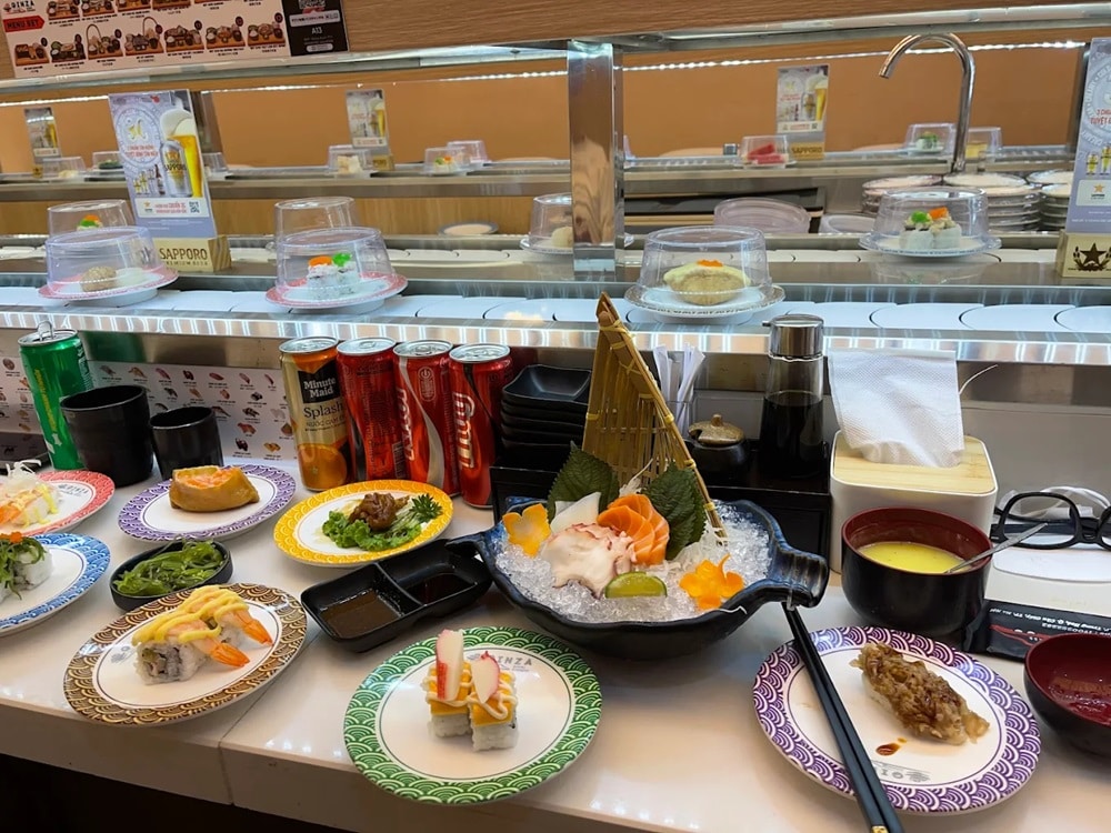 Các đĩa sushi và món ăn Nhật như sashimi, maki, salad rong biển, bánh xèo Nhật và chawanmushi (trứng hấp)